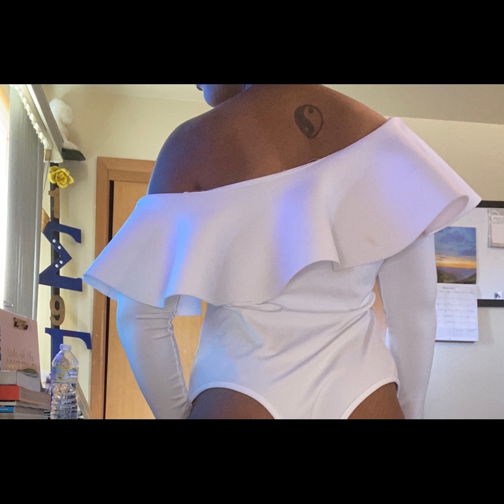White body suit, off the shoulder with details.
